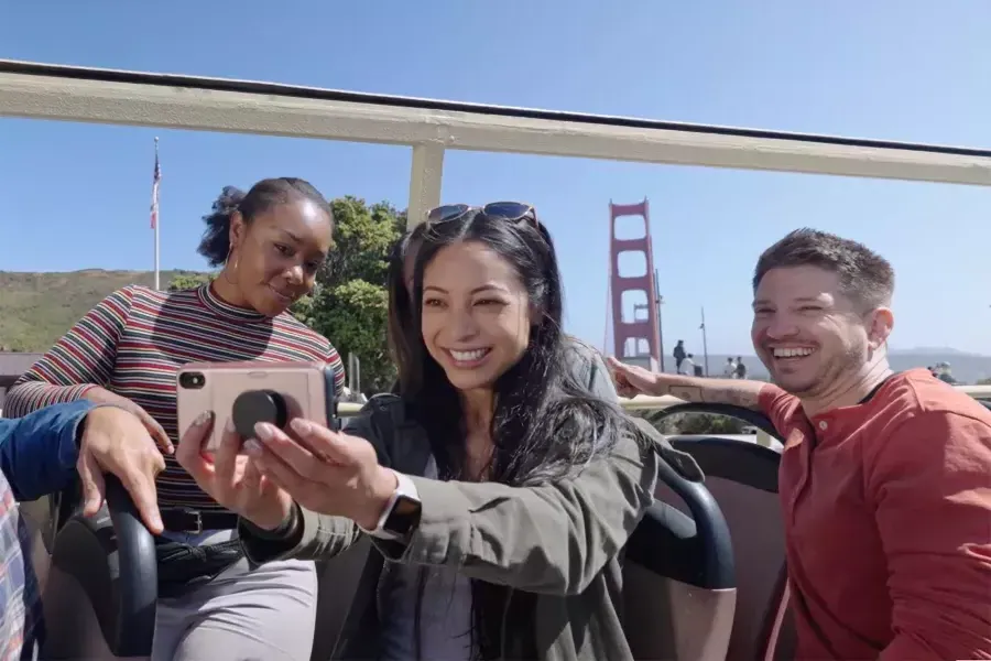 Un gruppo di visitatori si fa un selfie durante un 之旅 in autobus vicino al Golden Gate Bridge. San Francisco, California.